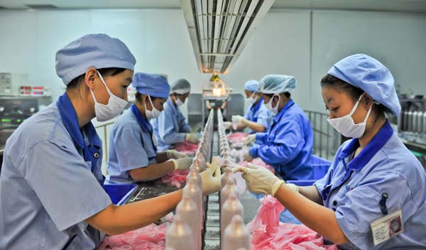 Workers with the Tianjin Human-care Latex Corporation inspect condoms on the production line on Nov 29, 2013. The company produces more than 600 million condoms every year. ZHAI JIANLAN / XINHUA 