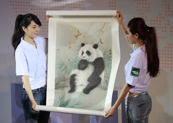 Workers show a painting of a panda donated by painter Chen Qiming on Monday in Chendu, Sichuan province, at the opening ceremony of an event to invite people from all over the world to paint drawings of pandas. Provided to China Daily