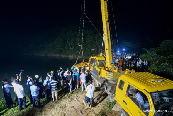 A kindergarten bus is hauled out of a pond at the mountainous Ganzi Village in the Yuelu District of Changsha, capital of central China's Hunan Province, July 11, 2014. [Photo: Xinhua/Bai Yu] 