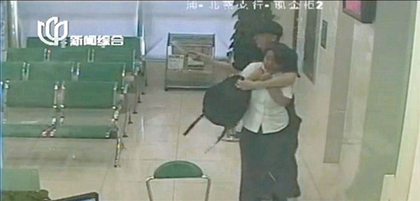 Surveillance camera footage shows bank clerk Yu Wenjing being held at knifepoint at the Beicai branch of the Agricultural Bank of China. 