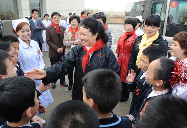 First lady Peng Liyuan talks with children suffering from HIV/AIDS at Red Ribbon middle school in Linfen, Shanxi province in November 2011. Provided for China Daily 