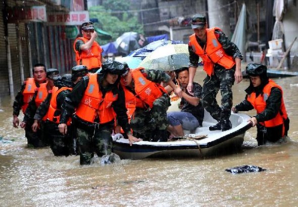 Rescuers evacuate people trapped in flood water in Jishou, central China's Hunan Province, July 16, 2014. Downpours hit Jishou since July 15. The Hunan Provincial Meteorological Station issued a red alert for rain on Wednesday. (Xinhua/Peng Biao)