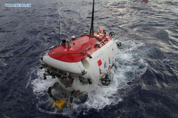 Jiaolong, China's first manned deep-sea submersible, is lifted out of sea water after a dive in the northwest Pacific Ocean, July 16, 2014. The submersible has launched a voyage in the northwest Pacific Ocean, during which it will research cobalt-rich crusts and life forms inhabiting the bottom of the sea. (Xinhua/Luo Sha) 