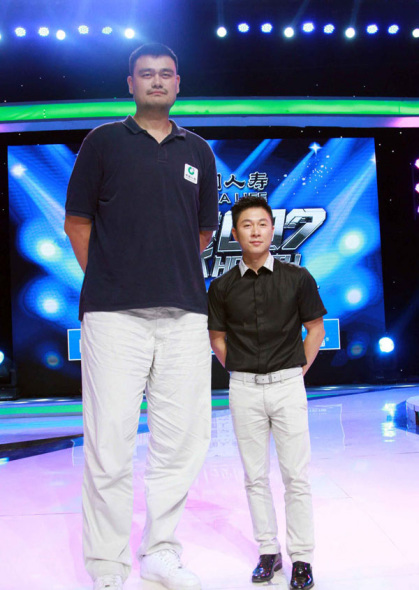 Retired basketball star Yao Ming (left) and former gymnast Li Xiaopeng pose for a photo as they join pre-recording of Zhejiang TV's medical game show Health 007 in Beijing on July 8, 2014. [Photo: people.com.cn]
