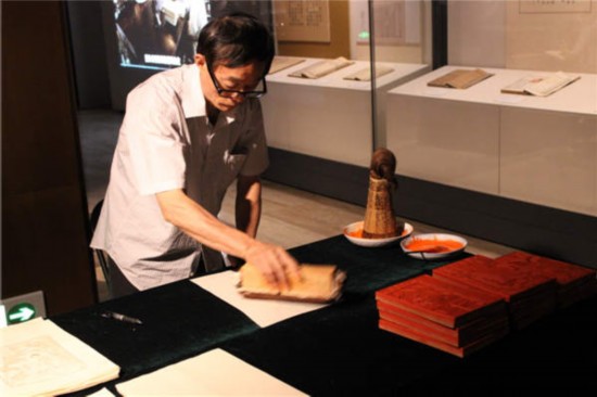 A librarian from NLC shows how to make a rubbing pieces at the museum. (Photos by Wang Kaihao / China Daily)