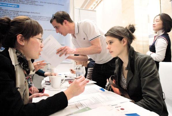 In this 2011 file photo, a foreign young woman applies for a position in a local company at a job fair especially designed for expats in Shanghai.  Wang Rongjiang/Shanghai Daily