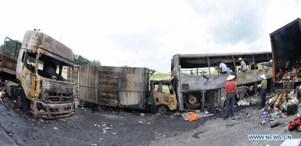 Photo taken on July 19, 2014 shows burnt vehicles after an explosion and fire on a section of the Hukun (Shanghai to Kunming) Expressway in central China's Hunan Province. At least 43 people are confirmed dead in the explosion and fire after a vehicle crash on the highway early Saturday morning. The accident happened at around 3 a.m. Saturday, when a van loaded with flammable liquid, probably alcohol, rear-ended a passenger coach. (Xinhua/Long Hongtao)