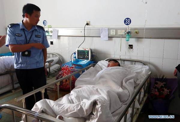 An injured man receives treatment in a hospital on Longhui County, central China's Hunan Province, July 19, 2014. At least 43 people are confirmed dead and another five injured in an explosion and fire after a vehicle crash on a central China highway early Saturday morning. The accident happened at around 3 a.m. on a section of the Hukun (Shanghai to Kunming) Expressway in Hunan Province, when a van loaded with flammable liquid, probably alcohol, rear-ended a passenger coach. (Xinhua/Guo Guoquan)