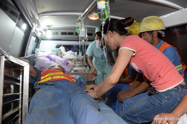 A worker receives treatment in an ambulance after he was saved from a railway tunnel collapse in Funing County of Zhuang and Miao Autonomous Prefecture of Wenshan, southwest China's Yunnan Province, July 20, 2014. Fourteen workers were rescued out of the tunnel collapse in Yunnan at early hours of Sunday after more than five days of rescue operation. The survivors were sent to a hospital nearby for medical treatment and psychological counseling according to their conditions, local authorities said. However, one person remains missing and the rescue operation continues. (Xinhua/Hu Chao)