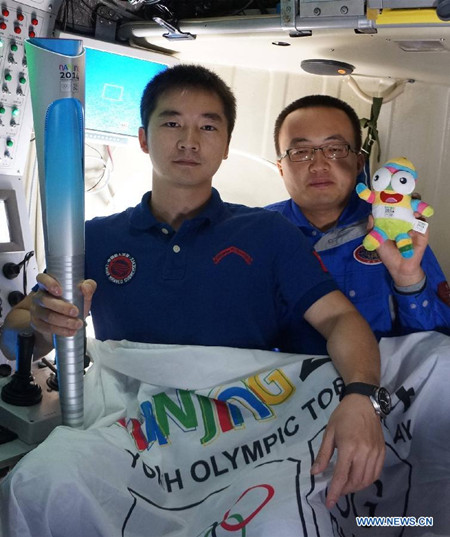 China's manned deep-sea submersible Jiaolong took a torch of the Youth Olympics to be held in China to the deep sea on Saturday in the northwest Pacific Ocean. (Xinhua photo)