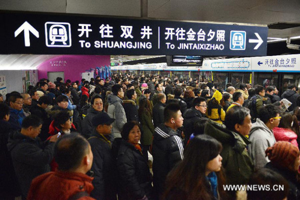 Commuters wait to board a train of subway line 10 at the Guomao Station, in Beijing, capital of China, Jan. 7, 2013.  [Photo: Xinhua/Wang Quanchao]