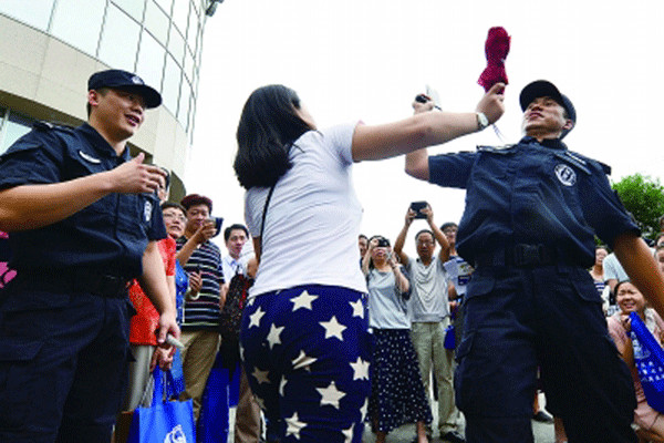 SWAT agents instruct a woman how to react to an attack during an event in Beijing on Tuesday at which anti-terrorism manuals were distributed. Guo Qian / for China Daily