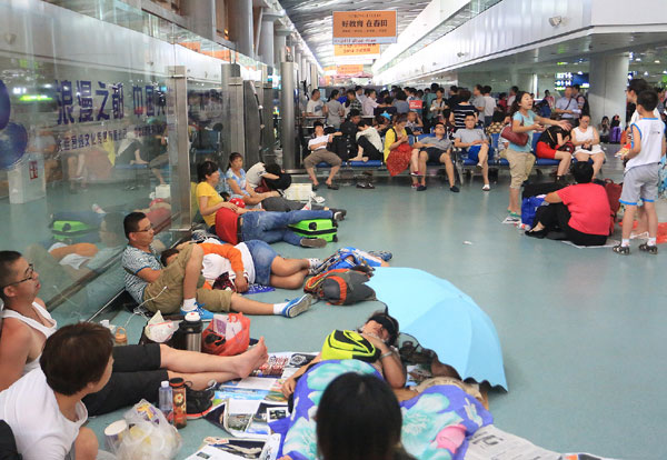 Passengers lounge around at Dalian airport in Liaoning province on Monday. Many flights have been canceled or delayed since Monday, affecting tens of thousands of passengers nationwide. Zhang Chunlei / for China Daily
