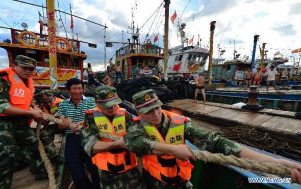 Soldiers help fishermen strengthen cables at a dock in Fuzhou, southeast China's Fujian Province, July 22, 2014. Coastal provinces in east China were bracing for Typhoon Matmo on Tuesday while southern regions were dealing with the aftermath of Rammasun. (Xinhua/Wei Peiquan)  