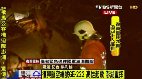A still image taken from TVBS footage shows a rescue worker at the crash site after TransAsia Airways flight GE222 crash landed in Penghu county, Taiwan, July 23, 2014.[Photo/tvbs.com.tw]