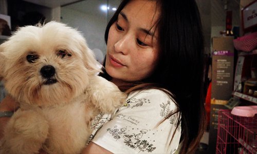 Ruan Xiaojing cuddles one of her favorite dogs sadly blinded in one eye in a savage attack. Photo: Huang Lanlan/GT