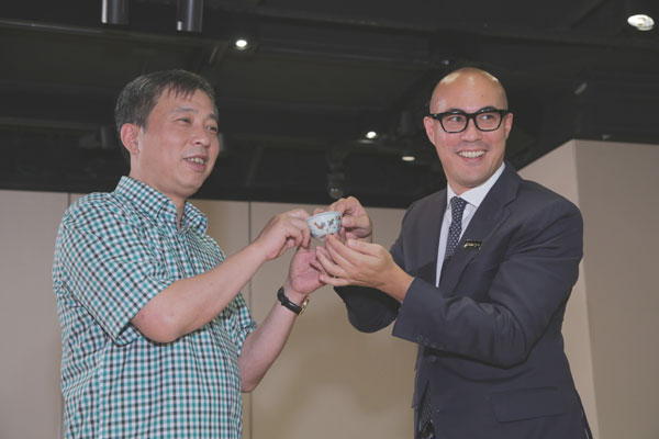 Liu Yiqian (left) receives the Chenghua chicken cup in Hong Kong. Photo provided to China Daily.
