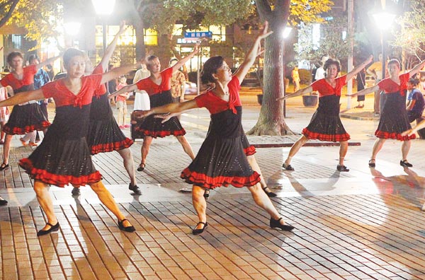 Middle-aged women don identical costumes for their daily dancing session downtown. Gao Erqiang/Shanghai Star