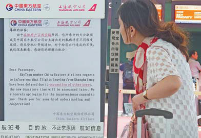 A woman reads a flight delay notice at Shanghai Hongqiao International Airport on Sunday. Gao Erqiang / China Daily