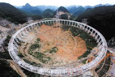 A photo taken 120 meters high shows a 500-meter aperture spherical radio telescope is under construction in Pingtang county, southwest China's Guizhou province. [Photo: Beijing News]