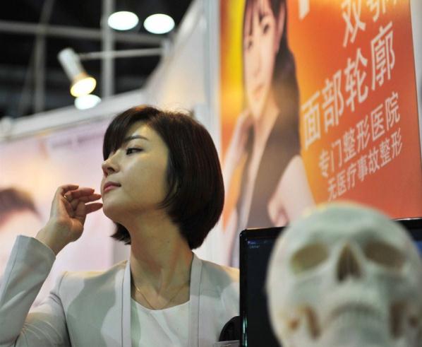 A model promotes for an South Korean plastic surgery hospital at an international fair for trade in services in Beijing.  Xinhua