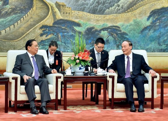 Wang Qishan (R), secretary of the Central Commission for Discipline Inspection of the CPC, meets with Secretary General of Lao People's Revolutionary Party Choummaly Saygnasone, in Beijing, China, July 28, 2014. (Xinhua/Li Tao)
