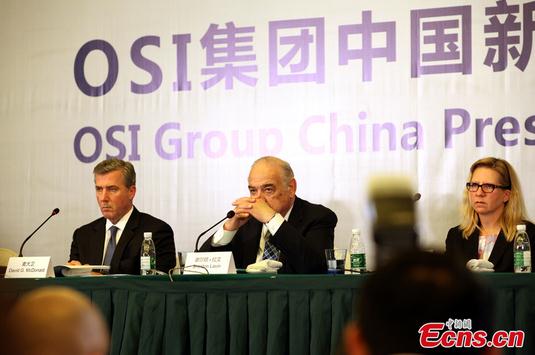 Sheldon Levin (middle), chairman and chief executive officer of OSI Group, is pictured at a press conference in Shanghai on Monday, July 28, 2014. (Photo: China New Service)
