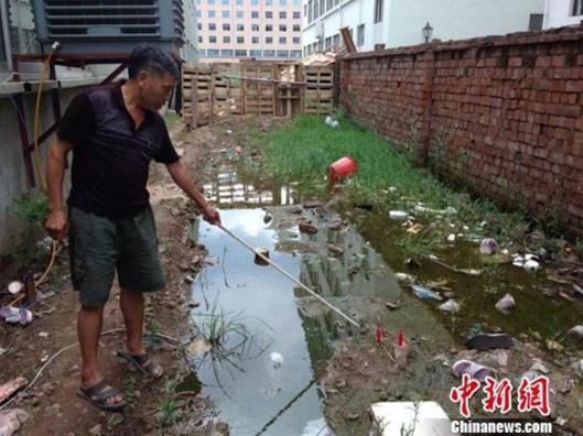 A man surnamed Yu lights two candles where he found a dead baby boy in Dongyang city, Zhejiang province. 