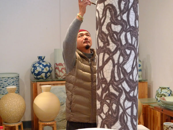 Bai Ming is seen with a ceramic work at his studio in Beijing.