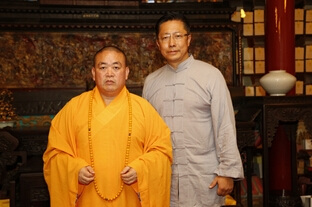 Li Yang poses for a photo with Shi Yongxin, the abbot of Shaolin Temple, on July 26, 2014.
