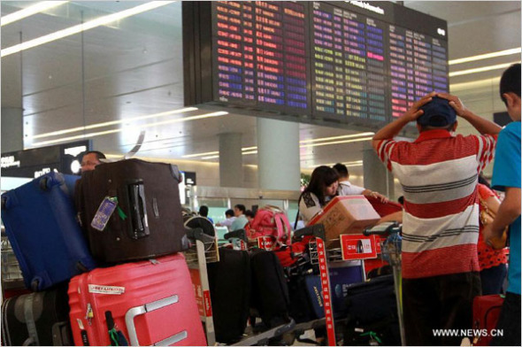 Passengers wait for transfer flight at Hongqiao airport in east China's Shanghai Municipality, July 29, 2014. [Photo: Xinhua/Pei Xin]