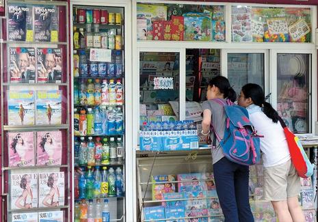 Two women talk to the operator of a newsstand on Shaanxi Road.  Wang Rongjiang/Shanghai Daily