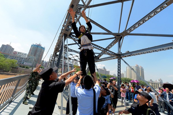 A 76-year-old man is rescued by police and firefighters after he attempted to commit suicide on a bridge across the Yellow River in Lanzhou, Gansu province, on July 3. PEI QIANG/CHINA DAILY 