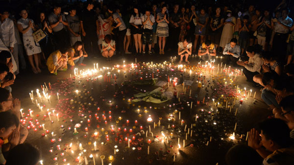 In a Kunshan city square on Saturday night, residents light candles to remember those who died or were injured in the factory explosion that morning. Shen Peng / Xinhua
