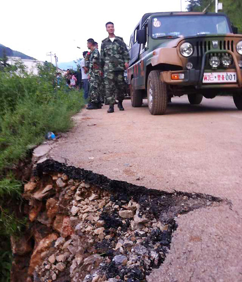 A military vehicle carrying supplies is stopped by damaged road on its way to quake worst-hit areas of Longtoushan township. [Photo by An Baijie/chinadaily.com.cn] 