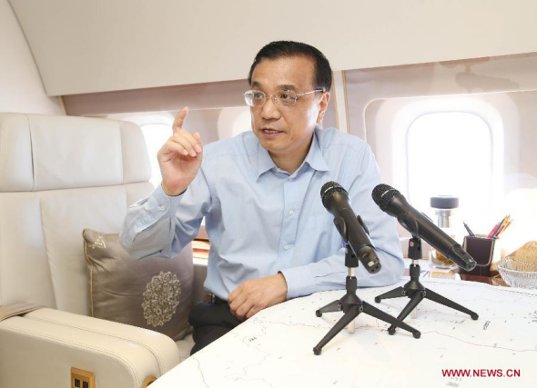 Chinese Premier Li Keqiang gives instructions on disaster relief aboard a plane heading for the earthquake zone in southwest China's Yunnan province, Aug 4, 2014. (Xinhua/Yao Dawei)