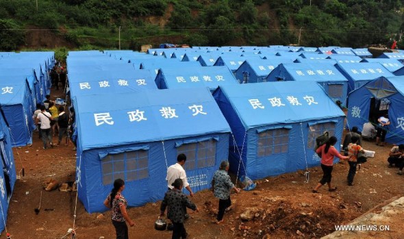 The affected residents move into the temporary tents in Longtoushan township of Ludian county, southwest China's Yunnan province, Aug 4, 2014. At least 398 people have been killed after a 6.5-magnitude earthquake rattled the province Sunday afternoon. (Xinhua/Chen Haining)