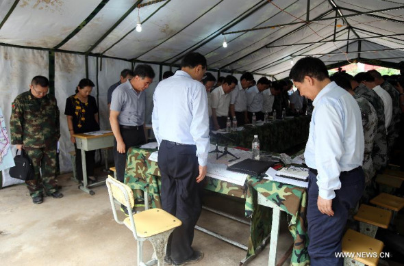 Chinese Premier Li Keqiang pays silent tribute to victims of a 6.5-magnitude earthquake ahead of a meeting on disaster relief work held in a tent at the quake epicenter in Longtoushan Town under Ludian County of Zhaotong, southwest China's Yunnan province, Aug 4, 2014. (Xinhua/Yao Dawei)