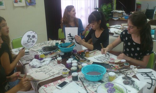 Foreign students write Chinese calligraphy during this year's Shanghai International Friendly City Youth Camp. 