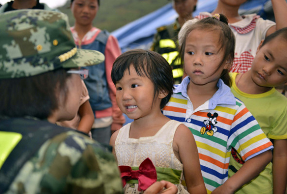 Psychological counselor Xu Xiumei (left) talks to children in Longtoushan, Yunnan province, on Thursday. Pan Zongwei / Xinhua 