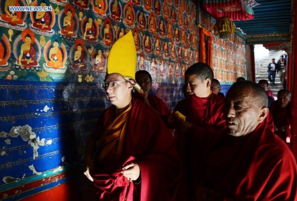 The 11th Panchen Lama (L), Bainqen Erdini Qoigyijabu, attends a religious ceremony to pray for the victims and survivors in quake-hit Yunnan Province, at the Tashihunpo Monastery in Xigaze, southwest China's Tibet Autonomous Region, Aug. 9, 2014. (Xinhua/Chogo)