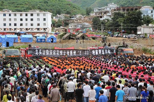 Rescuers and local residents mourn the quake victims at the memorial service in Longtoushan Township of Ludian County, southwest China's Yunnan Province, Aug. 10, 2014. A 6.5-magnitude quake that struck Ludian County on Aug. 3 has left 617 people dead and 112 missing. (Xinhua/Pei Xin)
