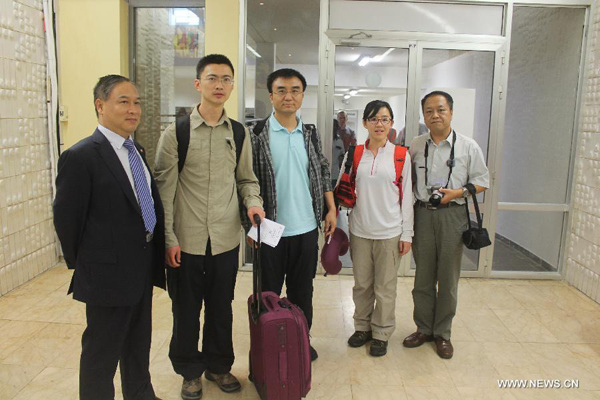 Three Chinese disease control experts (from 2nd L to 2nd R) arrive at the airport of Conakry, capital of Guinea, Aug. 11, 2014. The National Health and Family Planning Commission (NHFPC) announced on Saturday that China would send three expert teams and medical supplies to Guinea, Liberia and Sierra Leone to assist the prevention and control of the Ebola virus. (Photo/Xinhua)