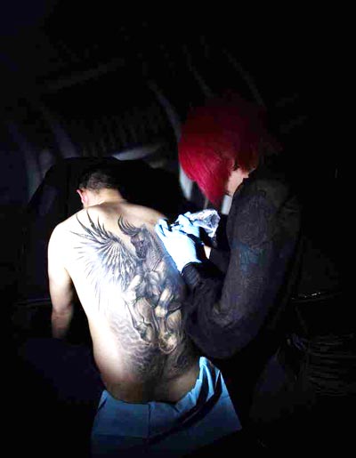 Jeanne Sun (right), owner of Jeanne Tattoo Studio in Beijing, works on a large tattoo on a customer's back. Sun became interested in tattoos when she was 16-years-old and was the first to open a tattoo shop in Tianjin at age 18.  Provided to chinadaily.com.cn