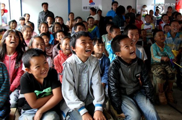Children watch a movie in the newly-built Hope Primary School in Longtoushan Township in earthquake-hit Ludian County, southwest China's Yunnan Province, Aug. 12, 2014. The Hope Primary School, sponsored by China Youth Development Foundation and Yunnan Youth Development Foundation, is the first one built after the 6.5-magnitude earthquake. The school, which is able to accommodate more than 500 students, has 20 prefabricated rooms with each covering 56.8 square meters. A 6.5-magnitude earthquake hit Ludian of southwest China's Yunnan Province on Aug. 3, which claimed at least 617 lives and injured thousands of others. (Xinhua/Pei Xin)