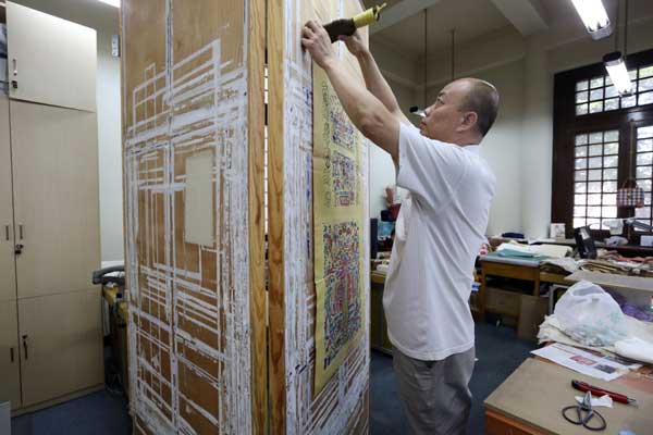 Restorers of ancient books work as book doctors at the National Library of China in Beijing. [Photo by Jiang Dong / China Daily]
