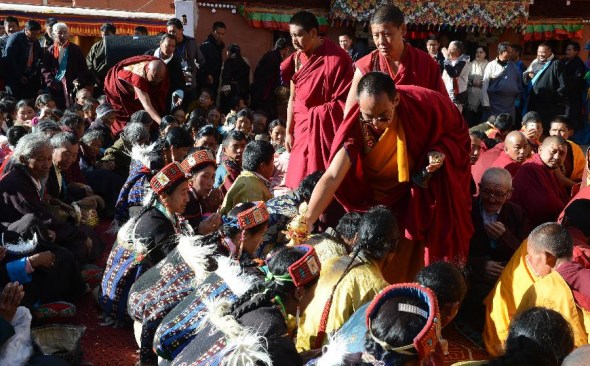 The 11th Panchen Lama, Bainqen Erdini Qoigyijabu, touches the head of a Buddhism follower to give blessings at a temple in Burang County of Nagri Prefecture, southwest China's Tibet Autonomous Region, Aug 16, 2014. (Xinhua/Chogo) 