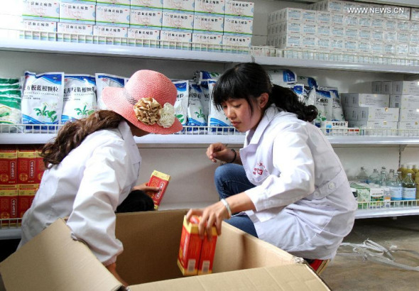 Medical workers arrange pharmaceuticals at the first makeshift hospital built after the 6.5-magnitude earthquake in Longtoushan Town of Ludian County, southwest China's Yunnan Province, Aug. 13, 2014. The makeshift hospital, which can accommodate 50 hospitalized patients and 150 clinic patients, was put into service on Wednesday. [Photo: Xinhua/Pei Xin]