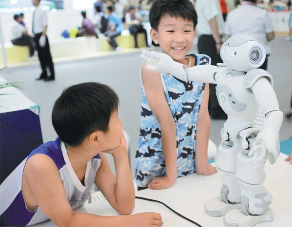 A dancing robot attracts the attention of two children at a science festival at Beijing Exhibition Center in July. More than 110 overseas and domestic organizations took part in the event, staged to increase the popularity of science. Zou Hong / China Daily