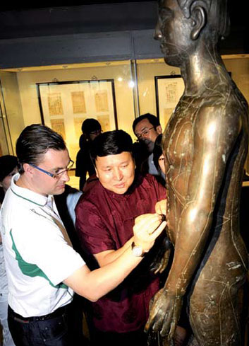 Museum curator Bai Yang explains acupuncture to a Western visitor. Photos Provided to China Daily